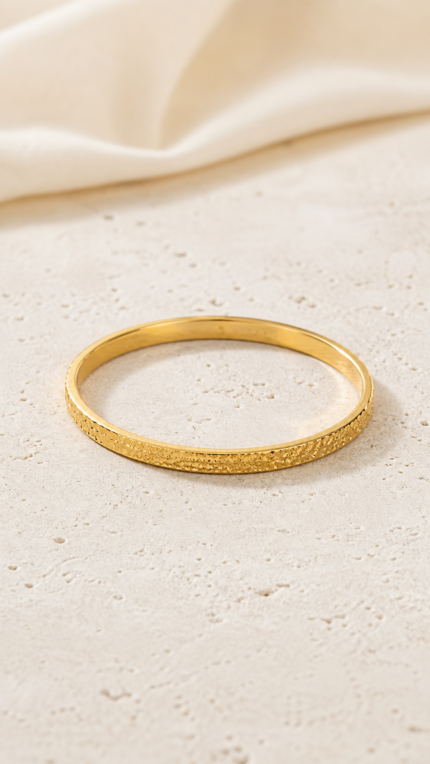 Aurone Crushed Ice Bangle lying naturally in a minimalist ivory scene