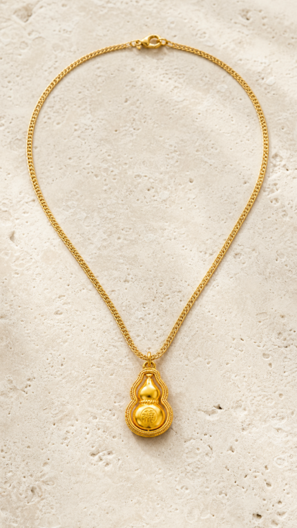 Aurone Fu Character Rotating Gourd Necklace laid flat in a minimalist stone scene