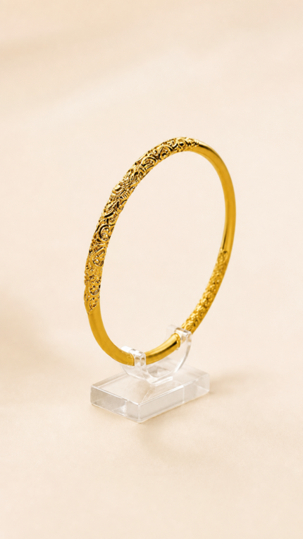Aurone Scrolling Vine Pattern Bangle centered on a transparent acrylic jewelry stand